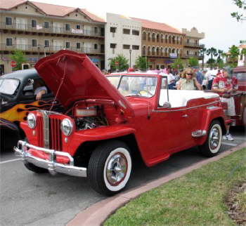 Lancer hubcaps, white interior and a small block Chevy engine are just some of the highlights on Bruce Andersons bright red Jeepster.  Bruce rolled into Cruisin Destination Daytona from Flagler Beach, FL.