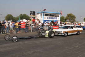 Historic, classic Top Fuel Dragsters are �push-started� down the return road in front of the cheering spectators.
